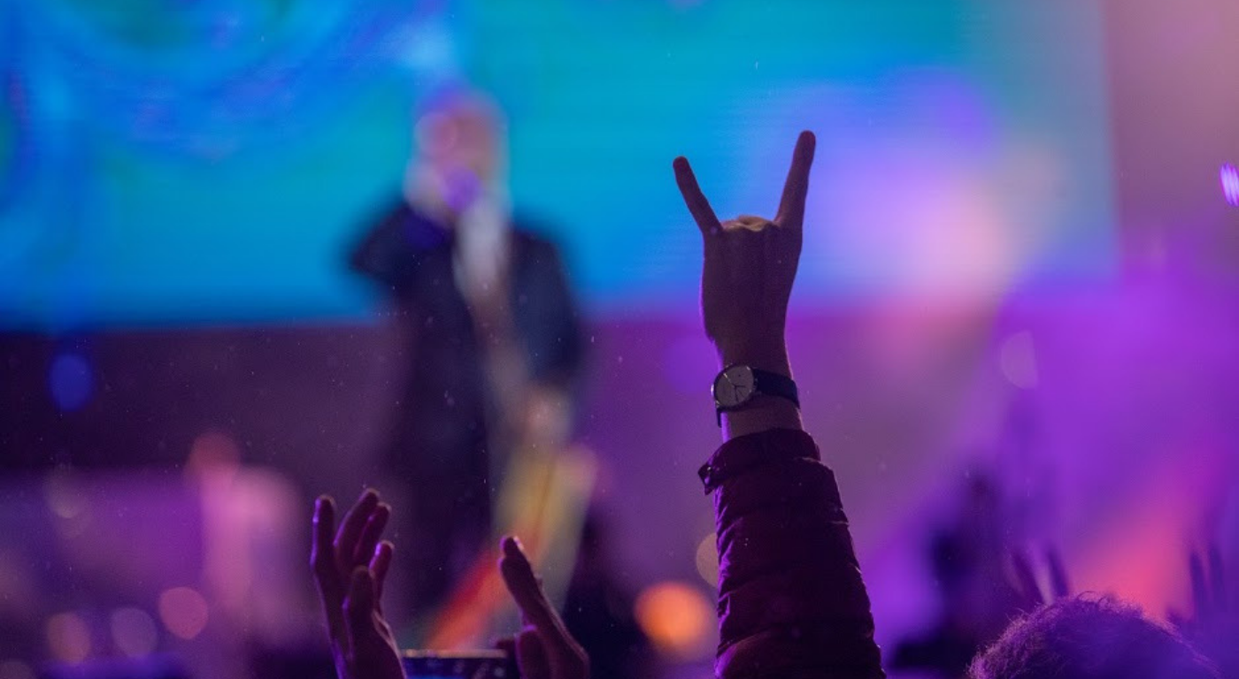 Un hombre alza su mano haciendo una señal en medio de una presentación de Rock al Parque 2019.