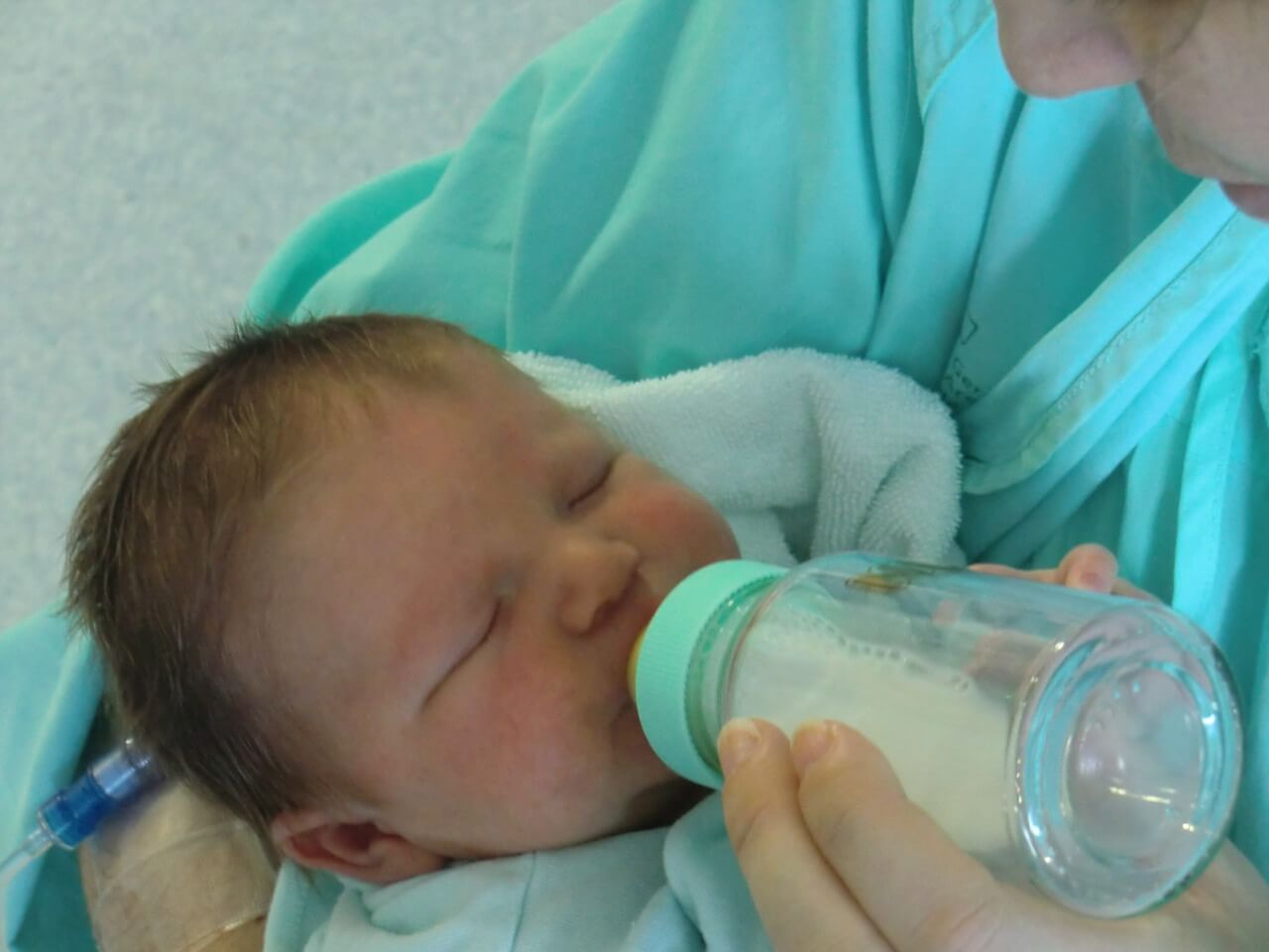 Imagen de un bebé tomando leche en biberón 