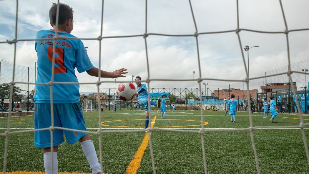 Niños jugando en una cancha de fútbol