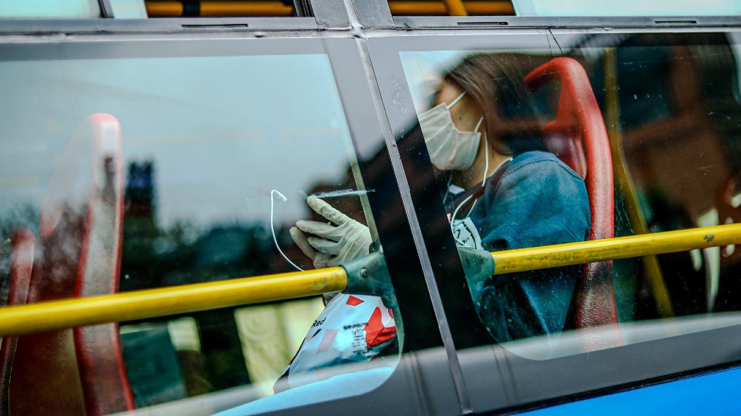 Mujer en TransMilenio con tapabocas