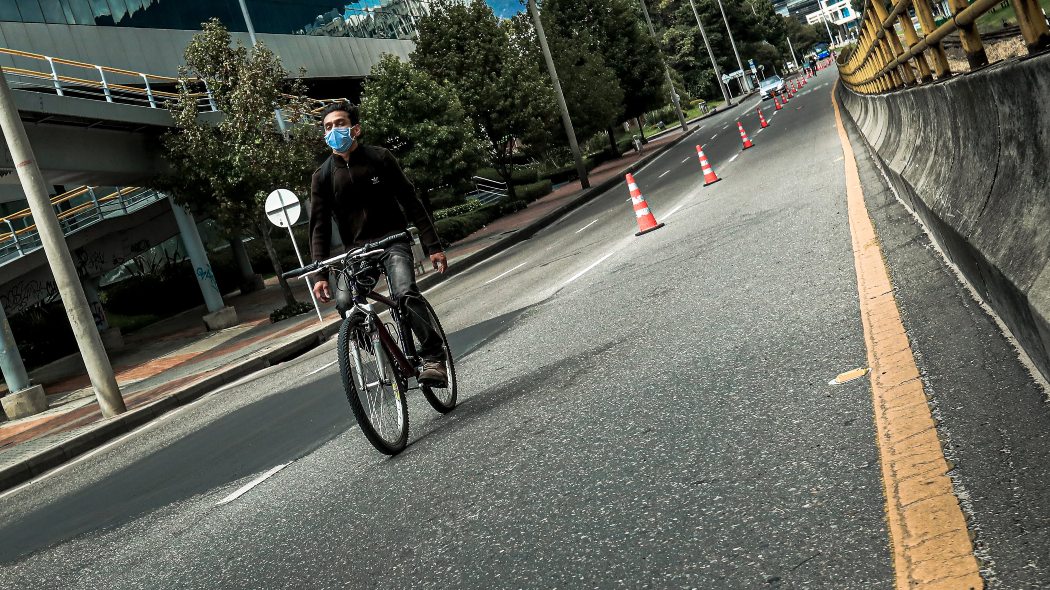 Joven montado en bicicleta por una vía de Bogotá