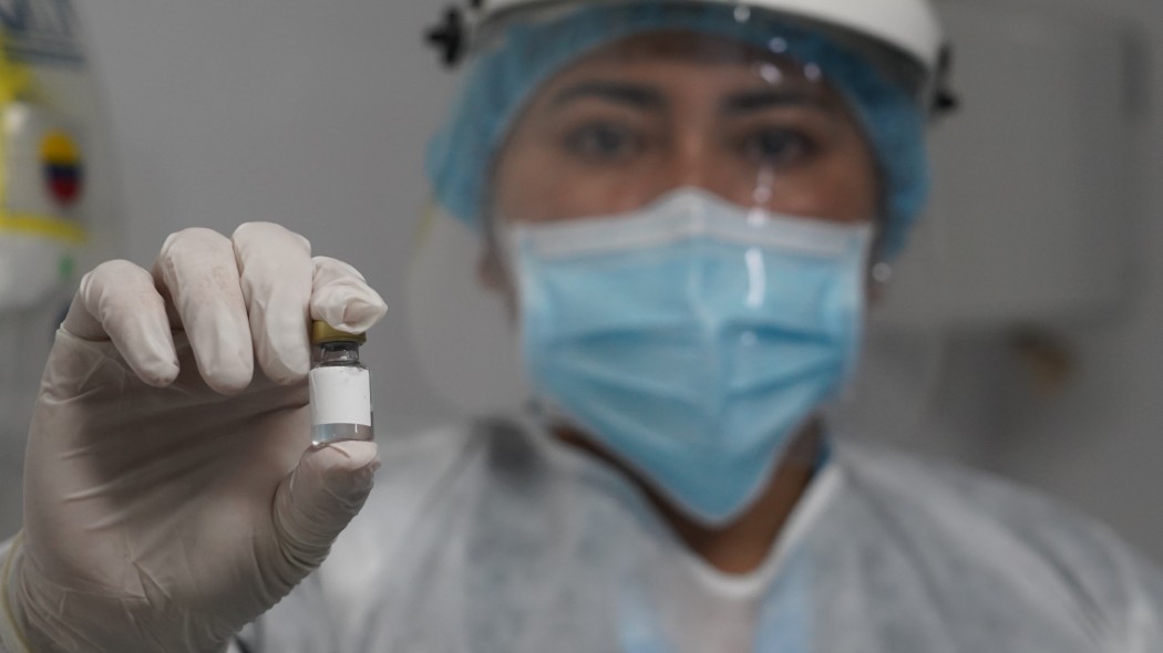 Persona con un vial en sus manos.