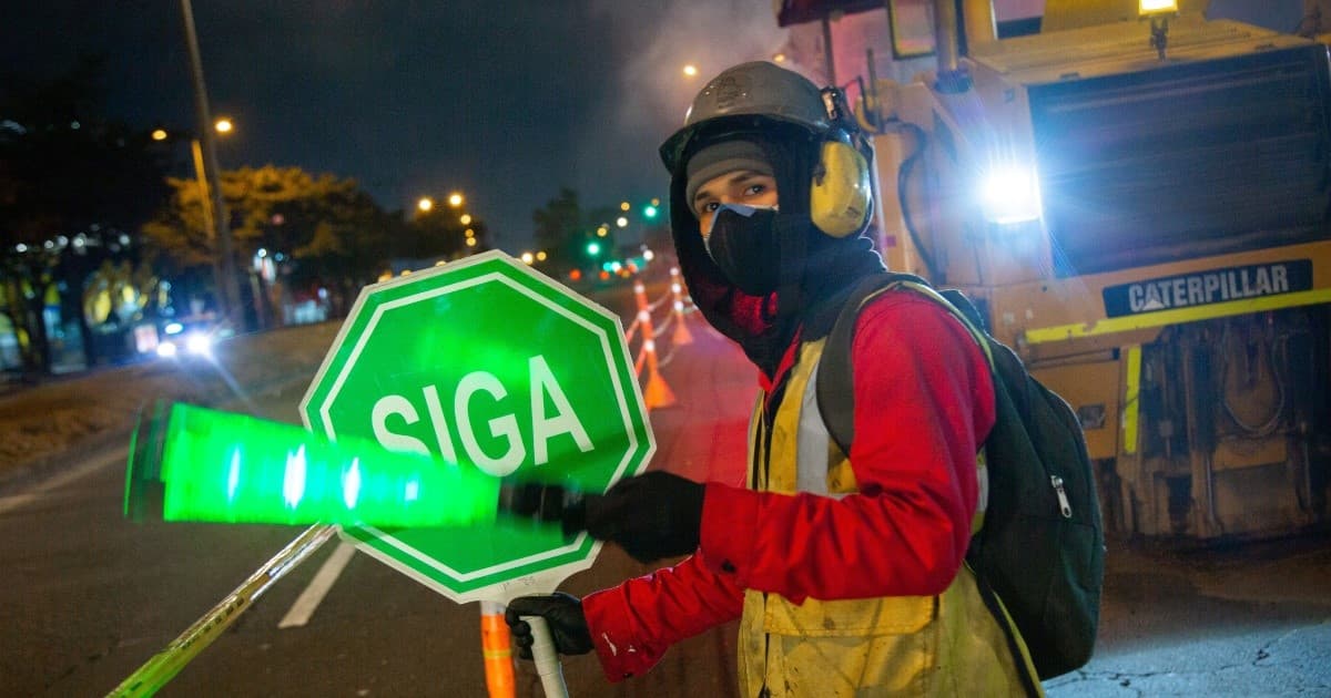 Personas que trabajan en jornada nocturna para mejorar la malla vial