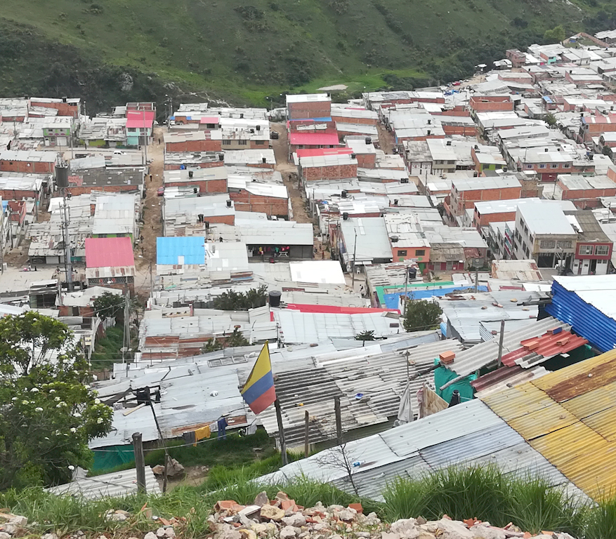 Una bandera de Colombia se alza entre los techos de las humildes viviendas - Foto: Alcaldía de Bogotá.