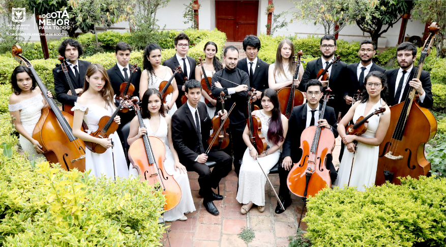 La Orquesta, conformada por hombre y mujeres, sostienen los instrumentos mientras posan