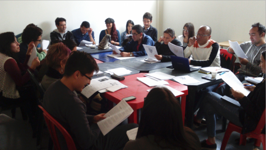 Un grupo de personas leyendo libros en una mesa redonda