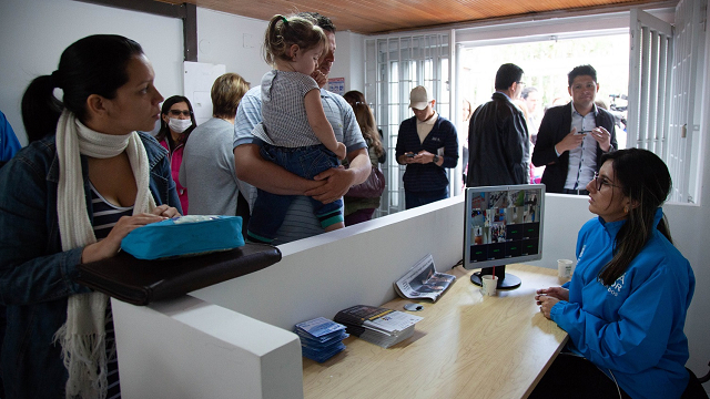 Centro Integral de Atención al Migrante, una mujer en la recepción atiende a varias personas migrantes 