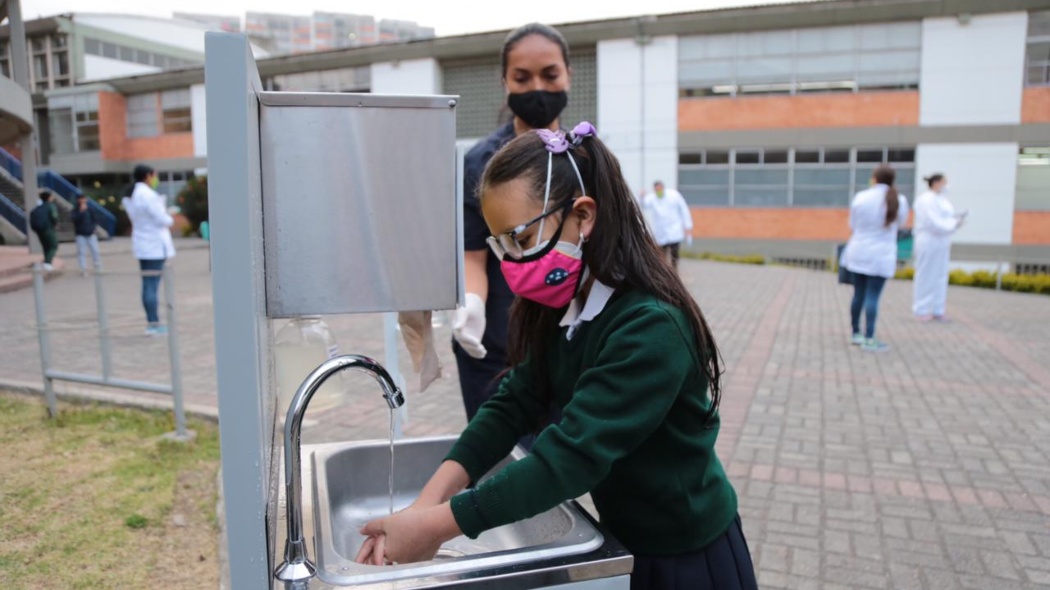 Niña lava las manos en colegio