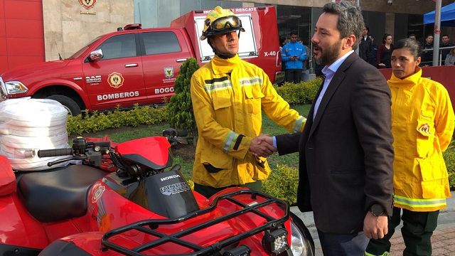 Un bombero del Cuerpo Oficial de Bomberos saludando al Secretaria de seguridad al lado de los nuevos equipos entregados a los bonberos