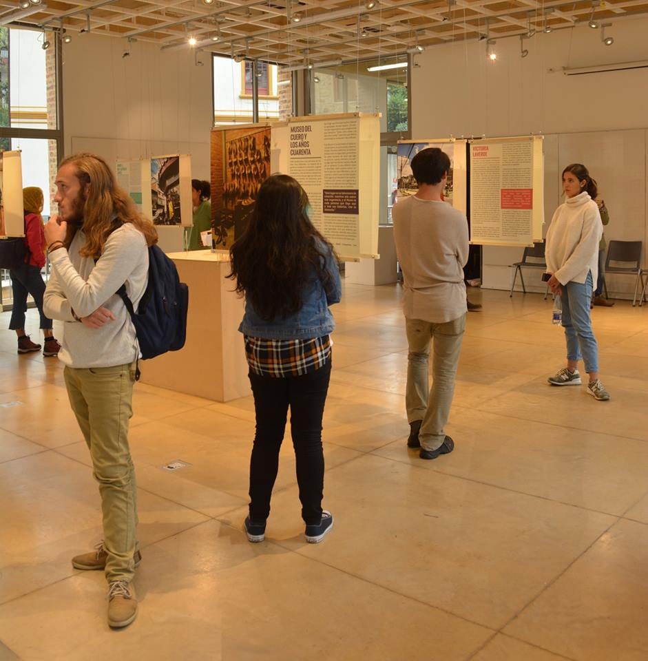 Una sala de exposición en el Restrepo, donde varias personas observan los pendones con la historia de las personas 