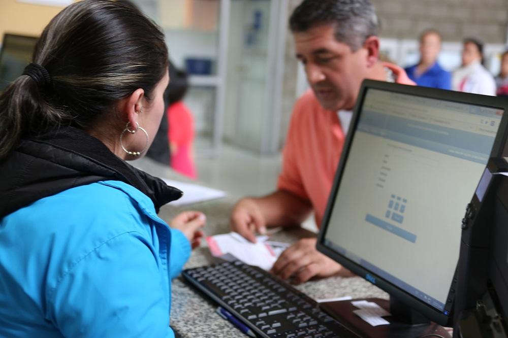 Un señora atendiendo a un ciudadano