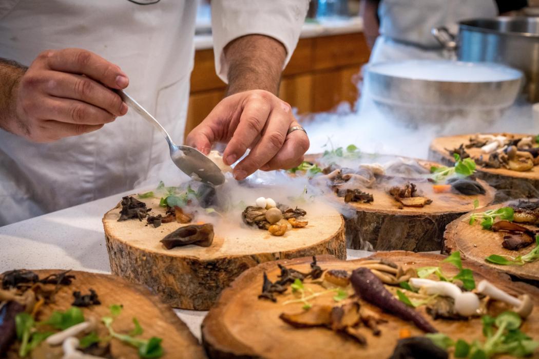 Primer plano de las manos de un chef terminando un plato.