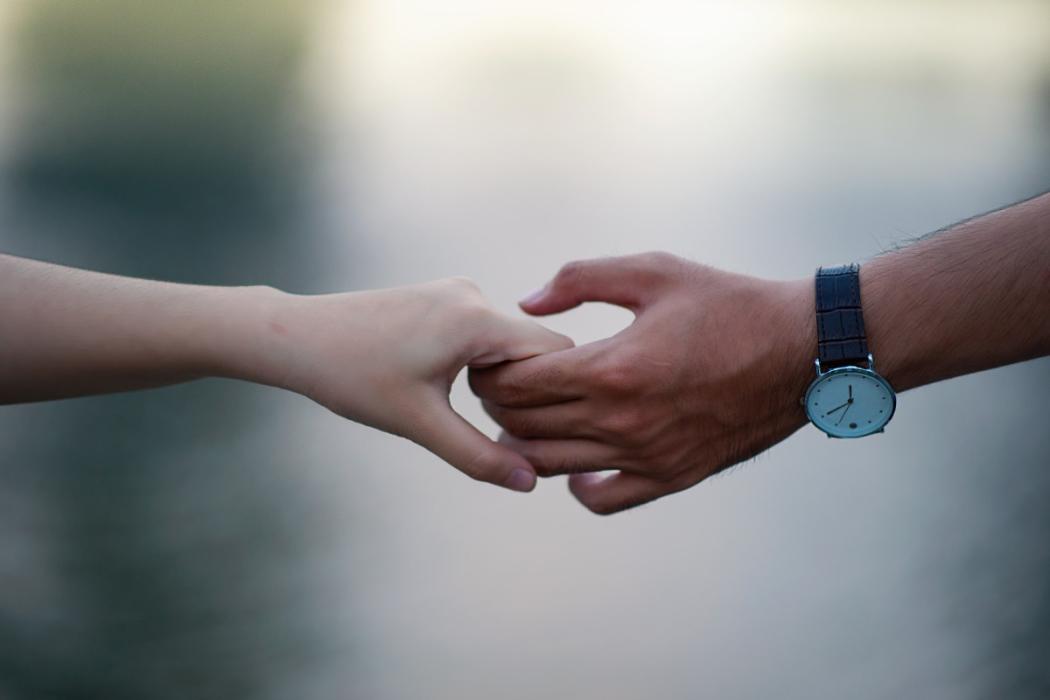 Mano de hombre y mujer agarradas.