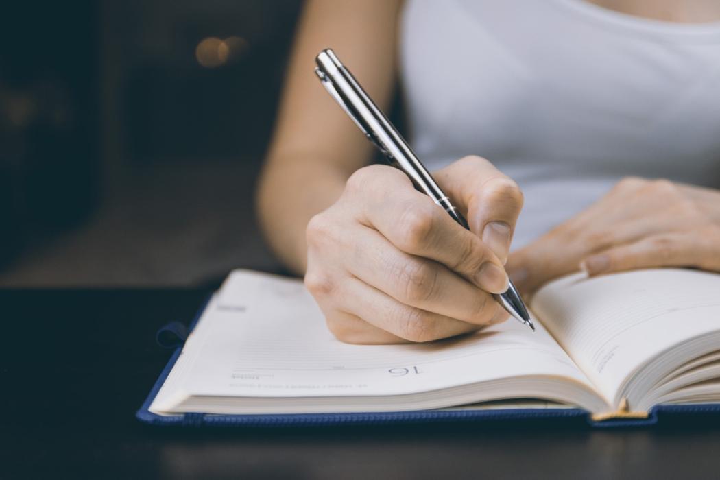 Mujer escribiendo en una libreta.