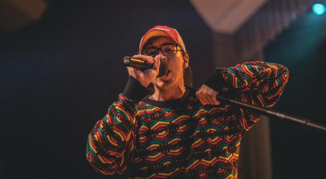 Hombre joven cantando en un concierto.