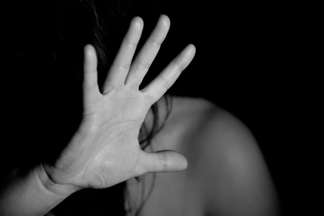 Foto en blanco y negro, una persona alzando la mano en defensa propia, primer plano de la mano 