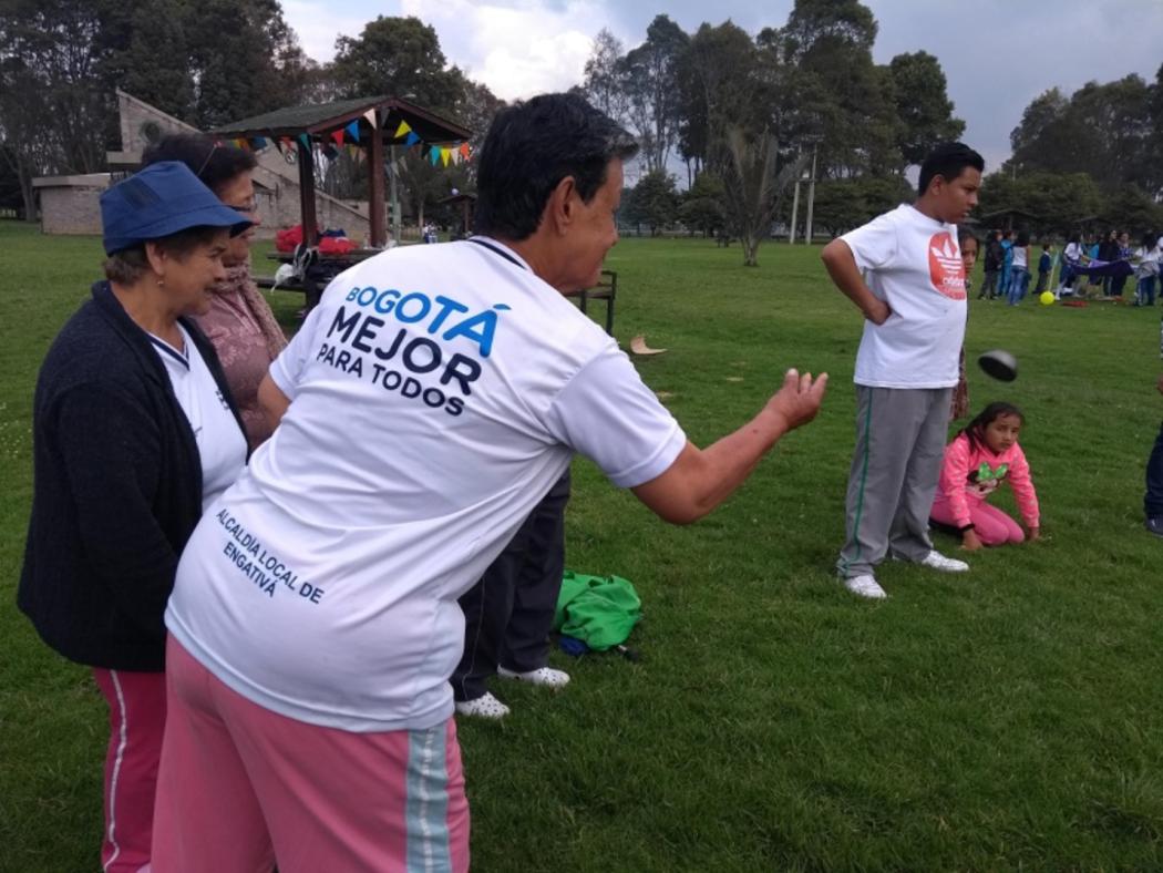 Adulto mayor jugando tejo al aire libre 