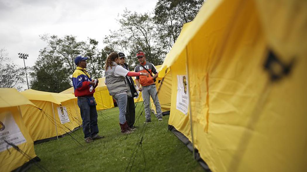 Varias personas en el campamento para venezolanos en Bogotá atendiendo y resolviendo inquietudes de esta población 