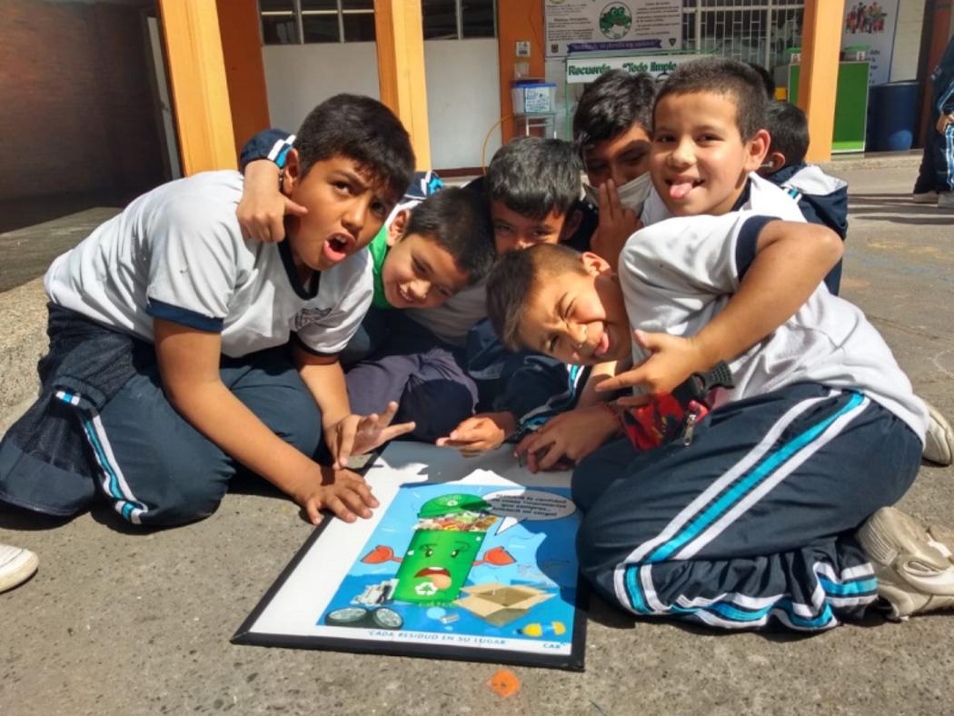 Cinco niños abrazados jugando un juego en el patio del colegio