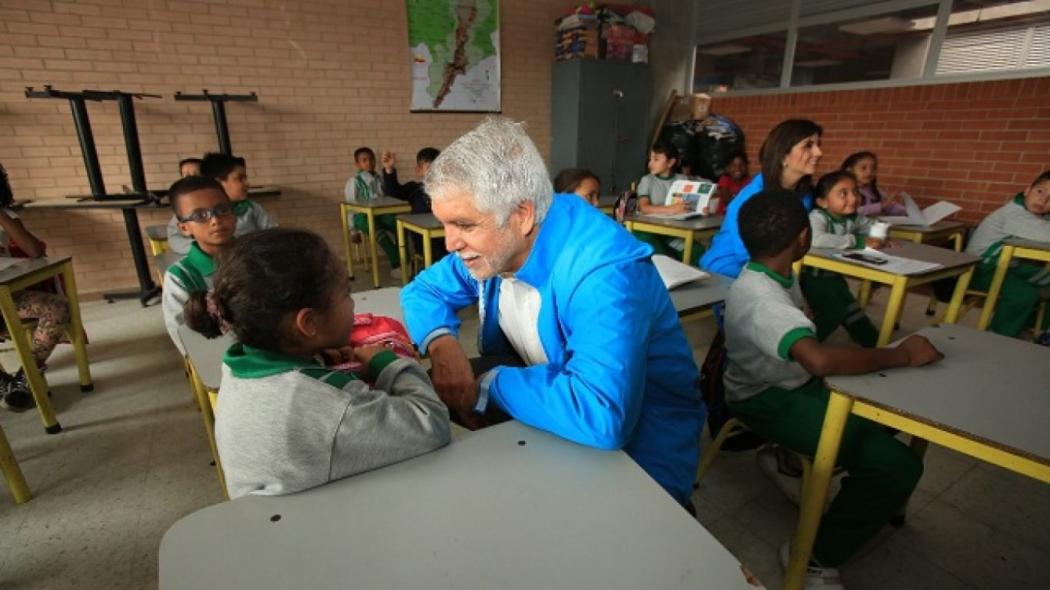 El Alcalde Enrique Peñalosa hablando con una niña en un salón de clases