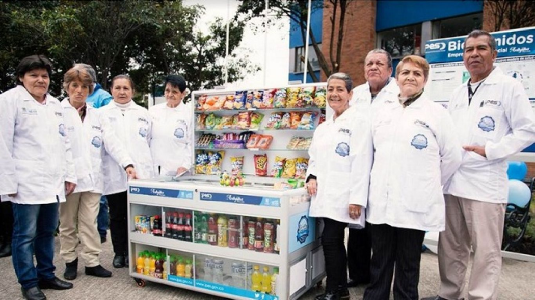 Vendedores informales posando para la cámara al lado de sus nuevos equipos mobiliarios 