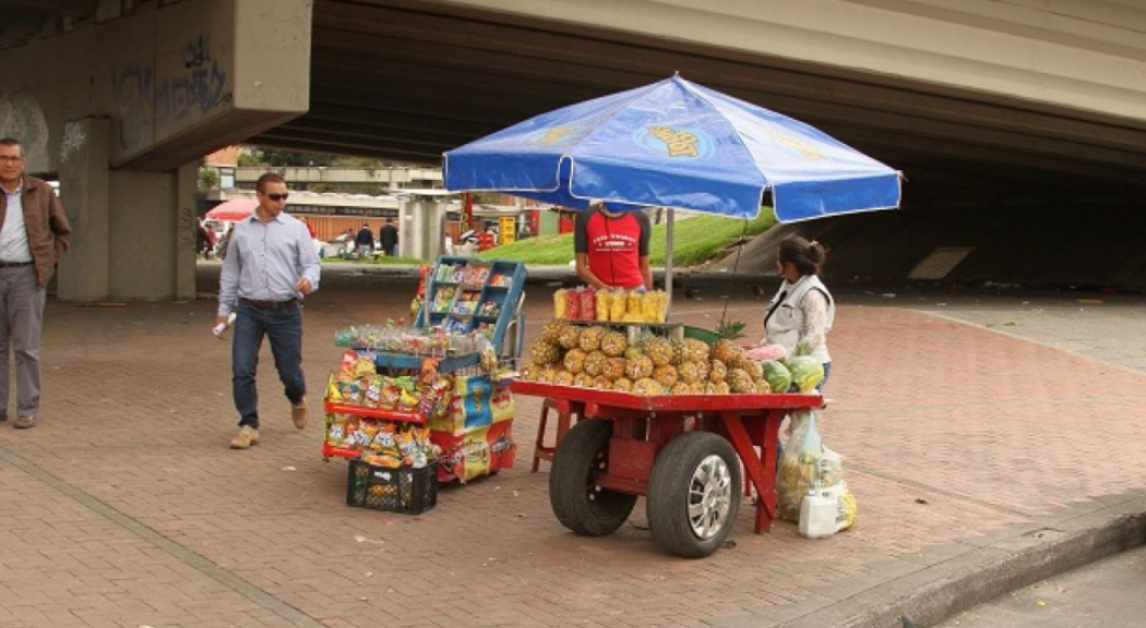 Dos carritos coloridos con productos comestibles y frutas sobre un andén.