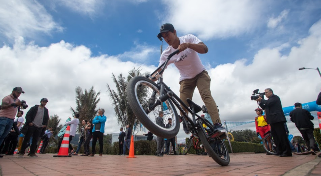 Un hombre joven hace trucos en una bicicleta.