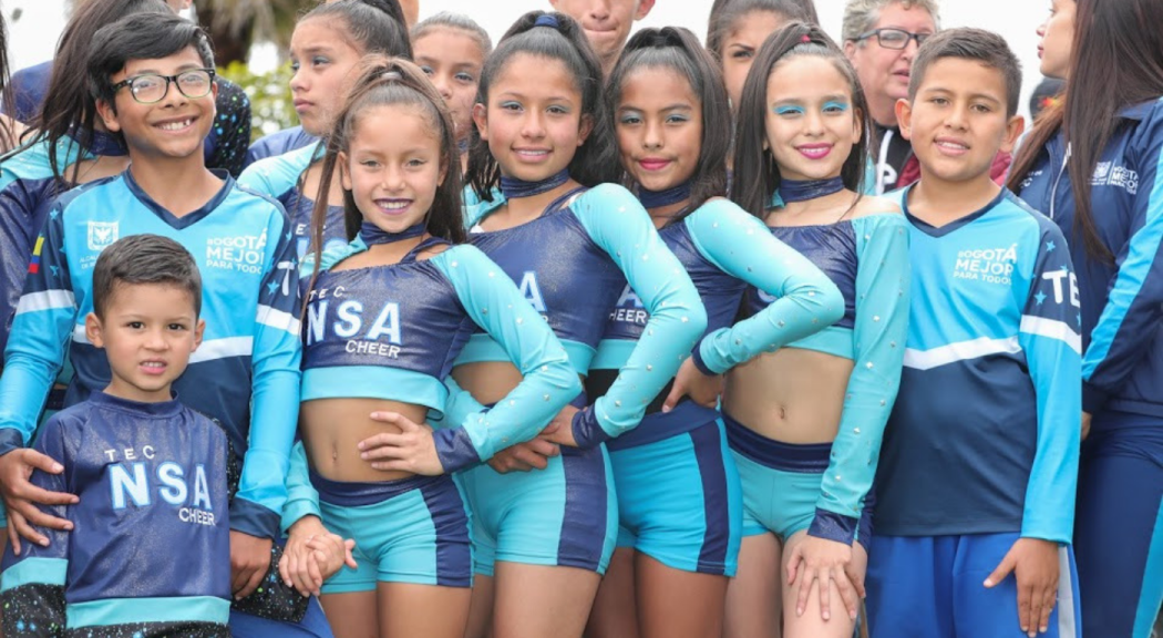 Un grupo de niños luce uniformes de porristas.