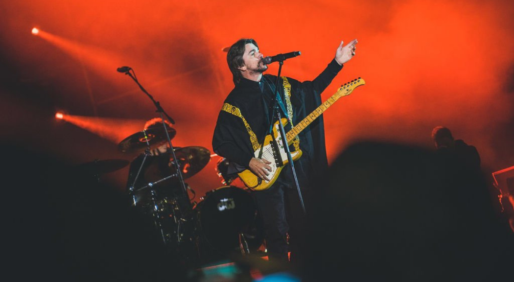 Juanes viste una ruana negra mientras canta en el escenario de Rock al Parque.