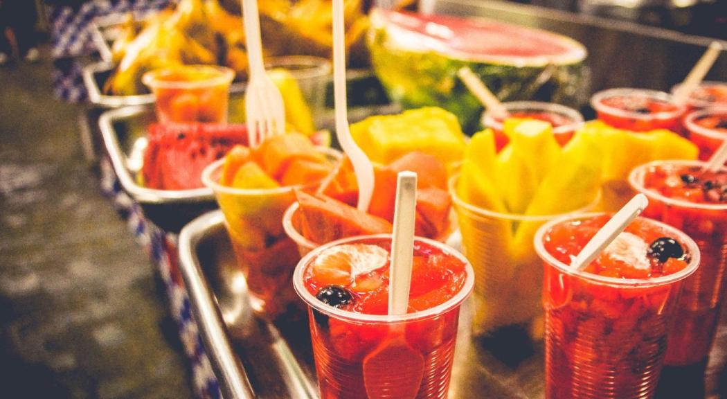 Escena típica de una plaza de mercado con vasos llenos de frutas.