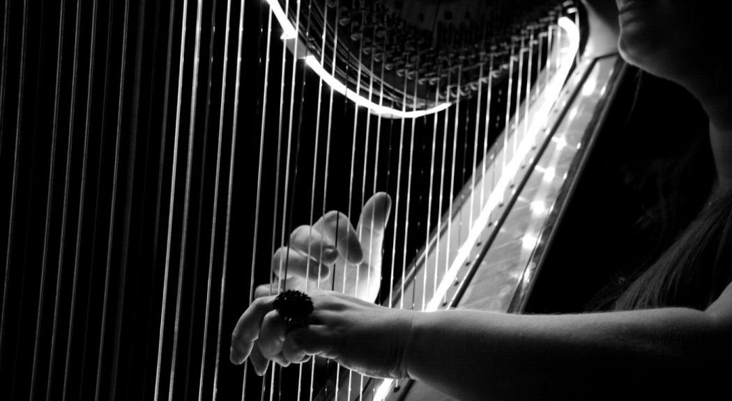 Retrato de una mujer en blanco y negro tocando el arpa.