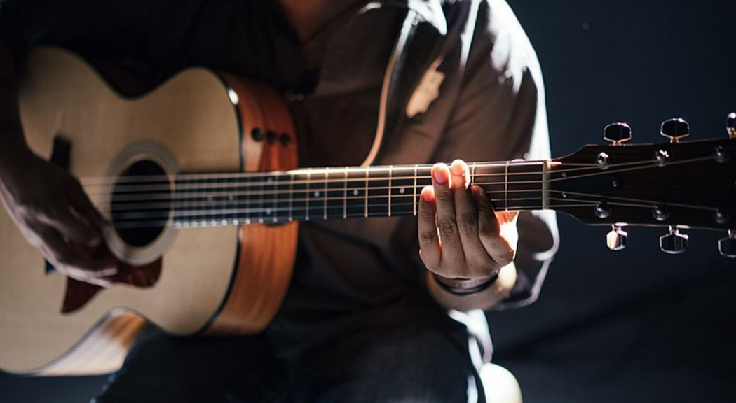 Primer plano de un hombre tocando la guitarra.