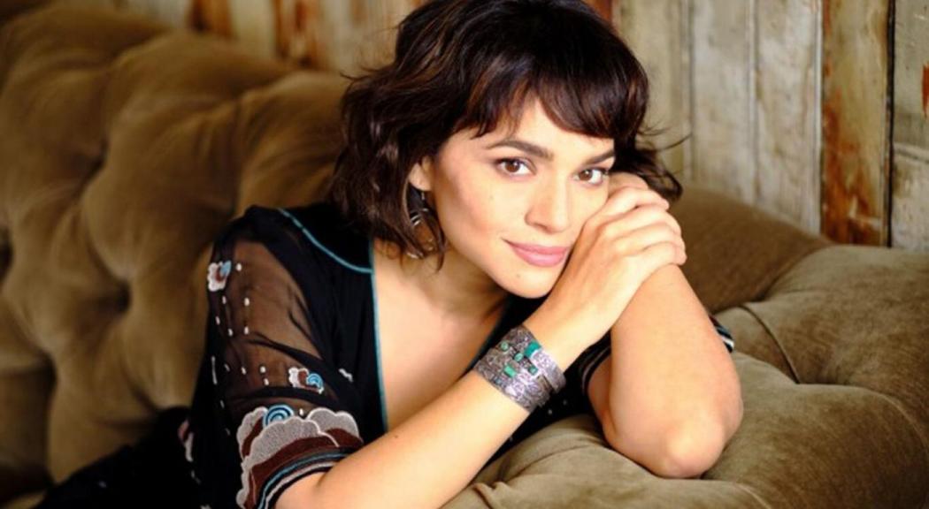 Retarto de Norah Jones apoyada sobre un sofá.