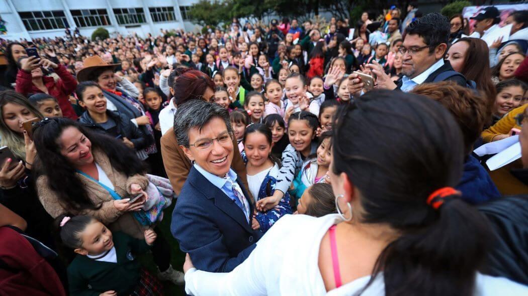 Claudia López reunida con varias personas que la reciben en un colegio de Bogotá