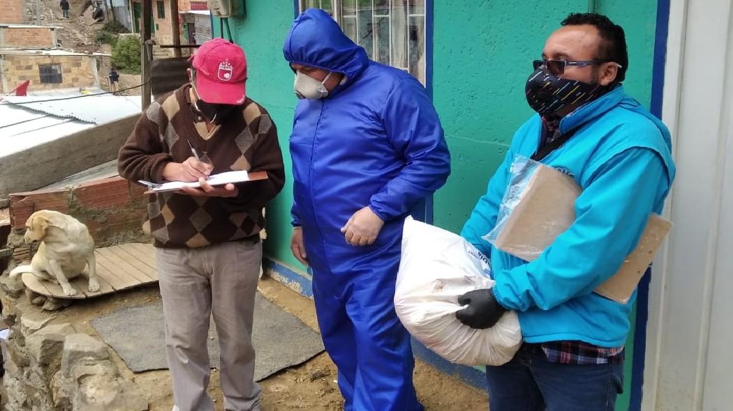 Voluntarios de la Secretaría General entregando ayudas