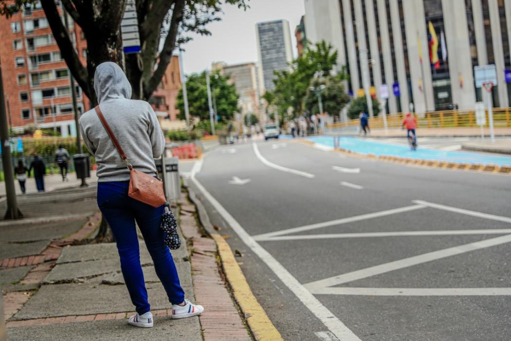 Fotografía de persona esperando transporte en la calle