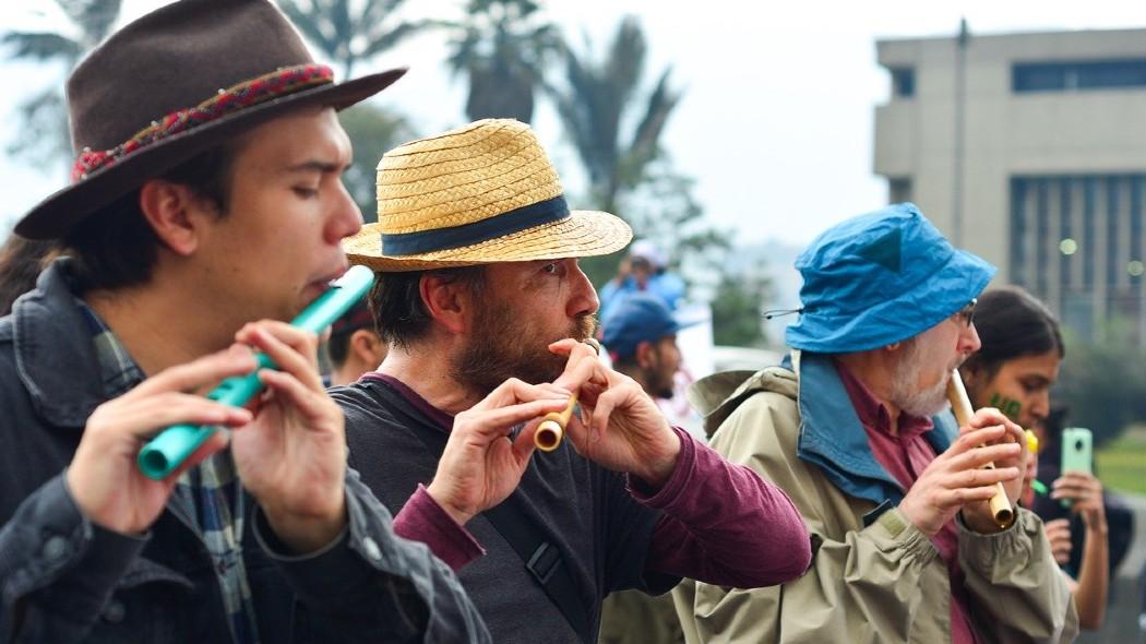 Personas reunidas tocando flautas