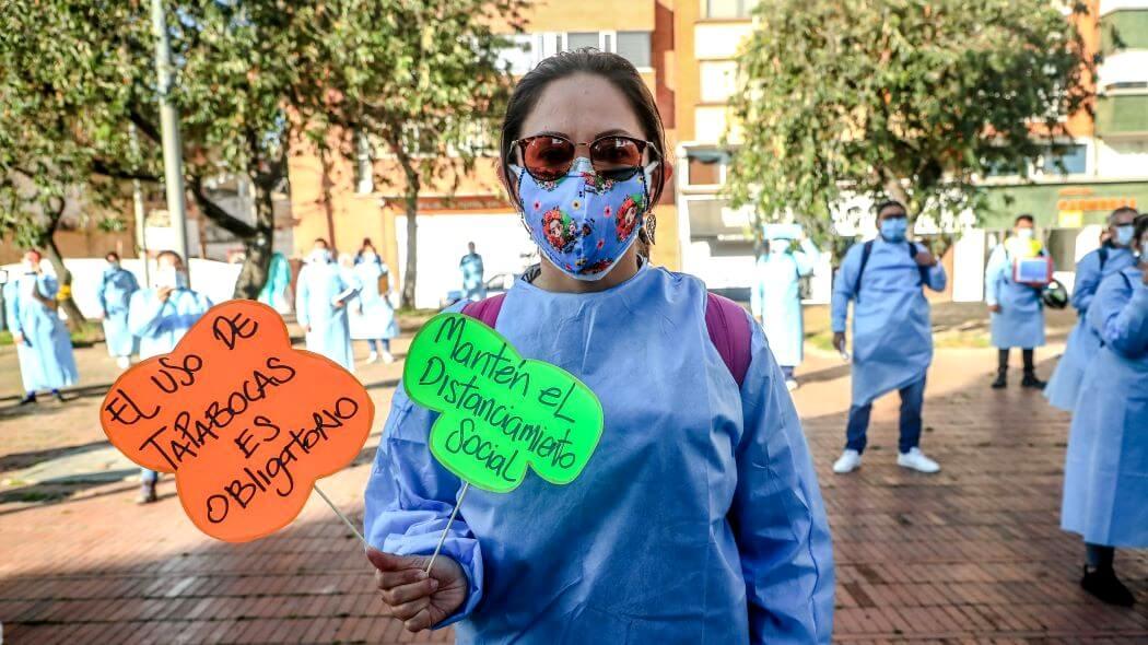 Imagen de una mujer que invita a usar el tapabocas y acatar el distanciamiento social.