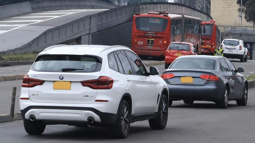 Fotografía de carros en vías de la ciudad.