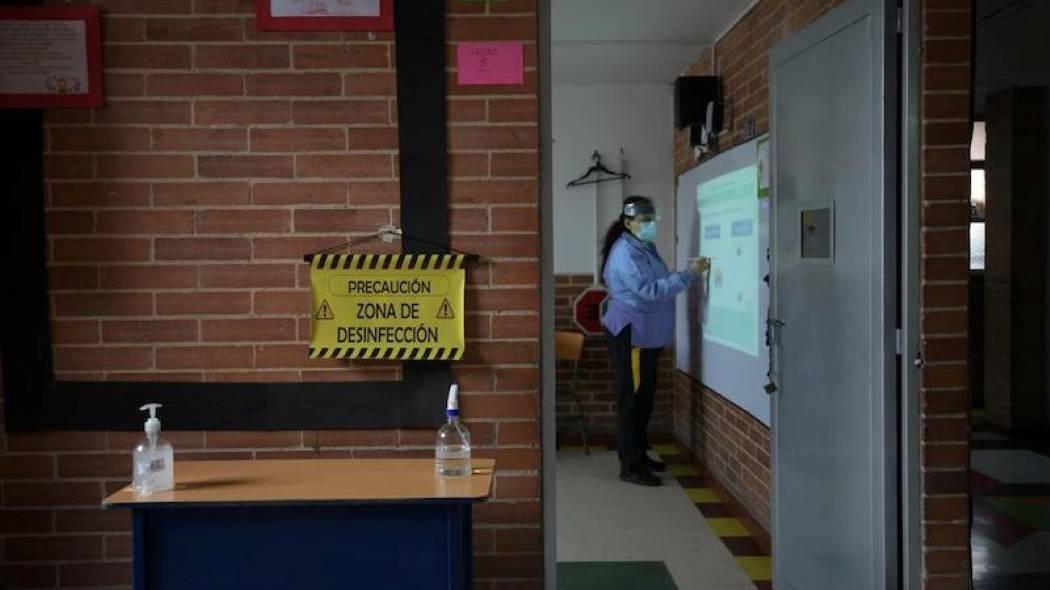 Imagen de un salón de clases con indicaciones de bioseguridad