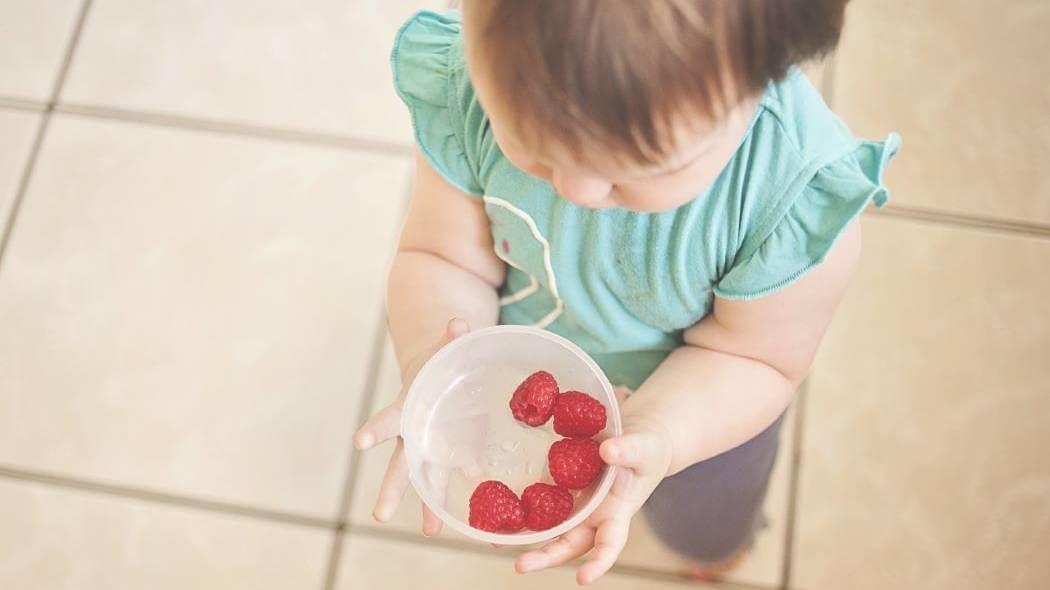 imagen de una niña alimentándose con frutas 