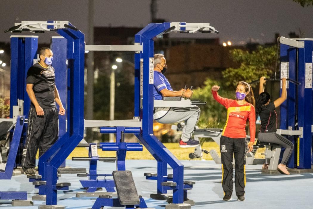 personas entrenando en un gimnasio nocturno de la ciudad