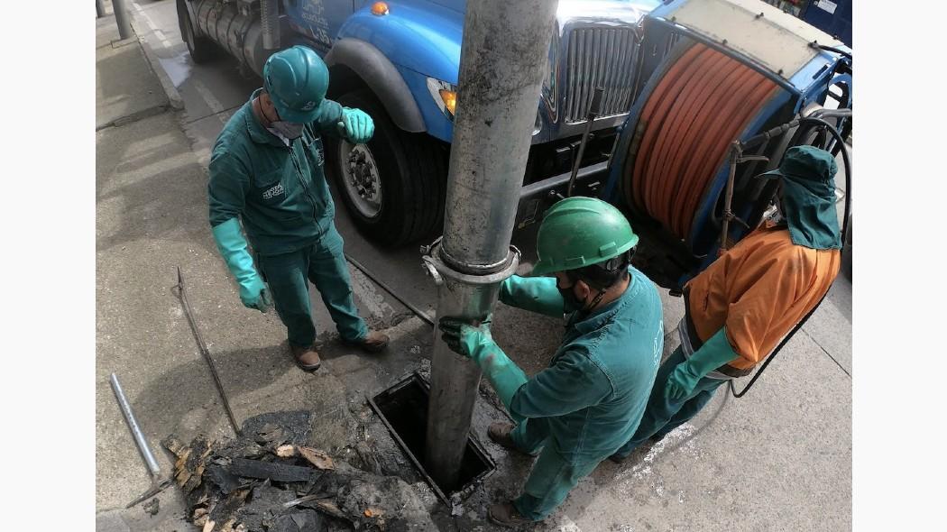 Personas del acueducto trabajando en la máquina de limpieza.