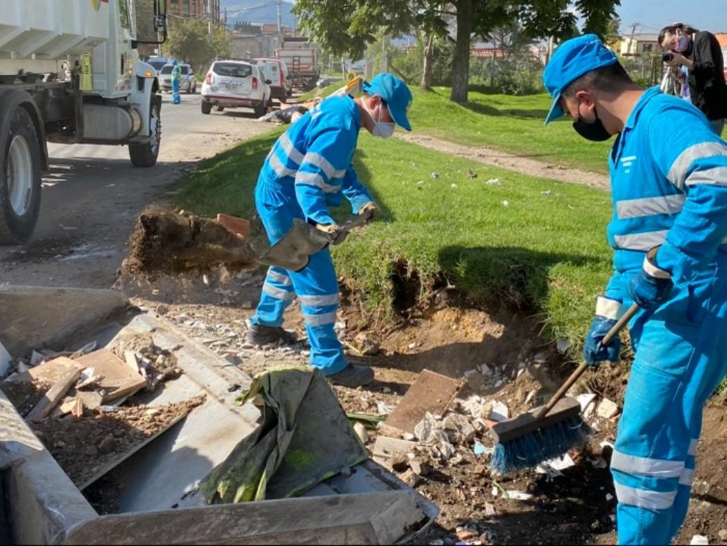 Personas barriendo y recogiendo escombros en la calle