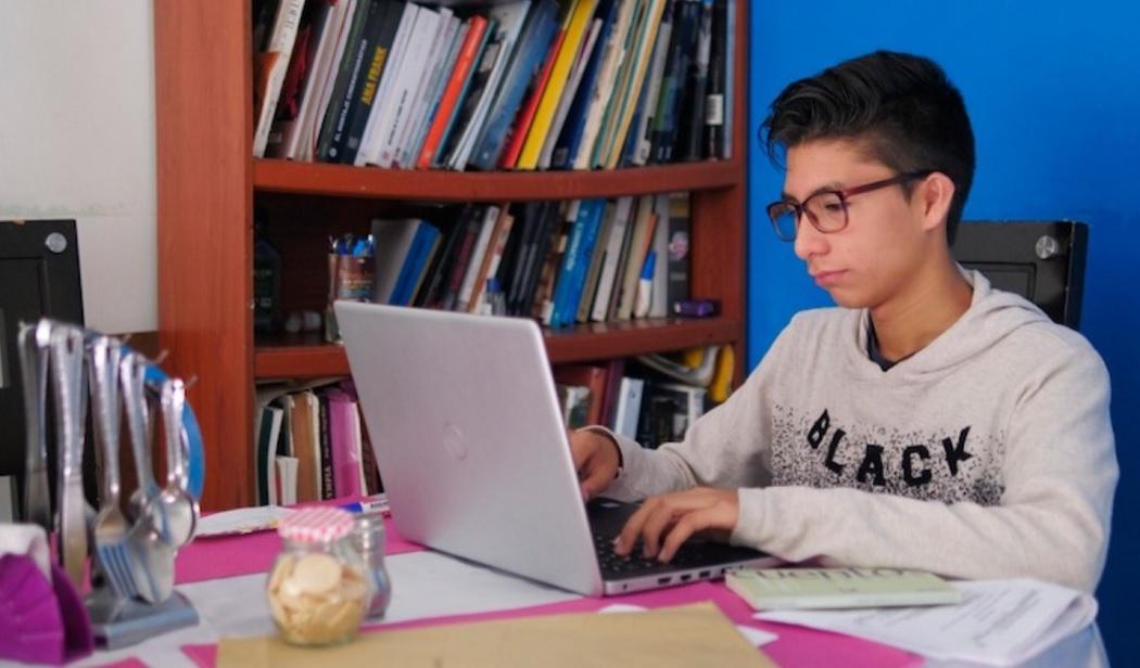 Joven escribiendo en computador