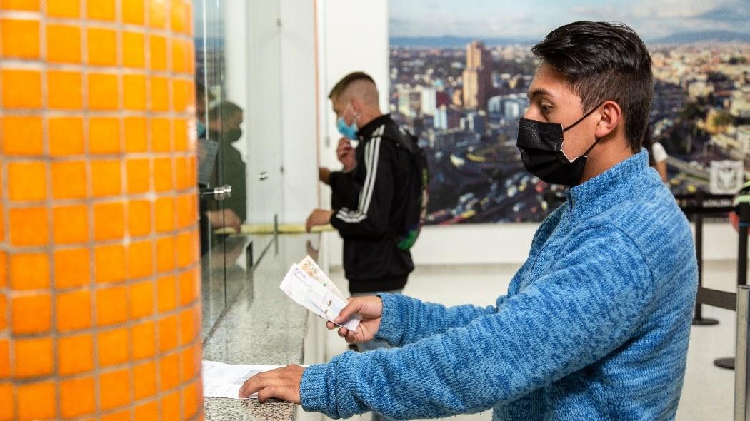 Persona pagando un comparendo en una ventanilla.