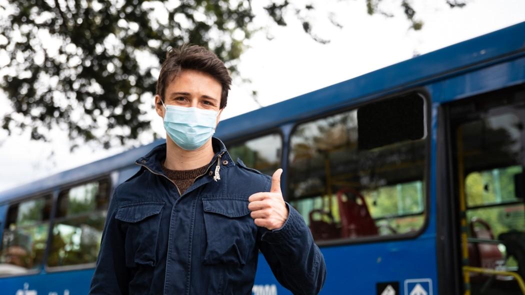 Persona al lado de un bus del SITP.