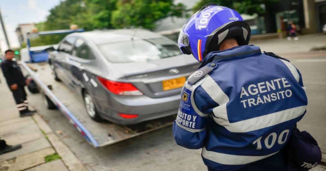 ¿Dónde reportar un carro mal parqueado frente a un garaje en Bogotá?