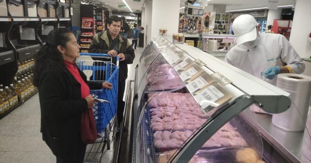 Personas frente a un refrigerador de carnes