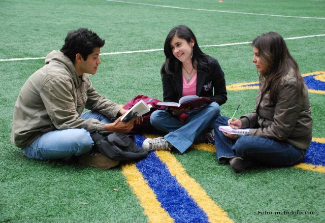 Tres personas se sientan juntas en el piso.